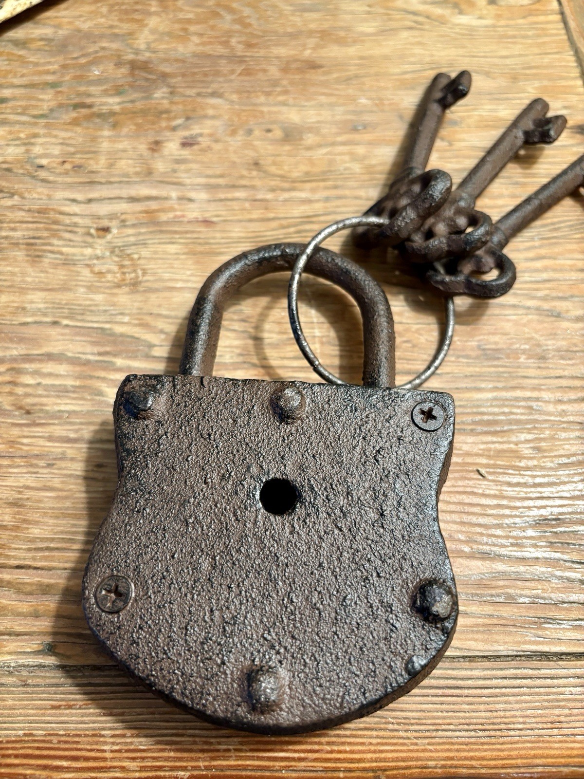 Vintage cast iron padlock with three skeleton keys on a ring.
