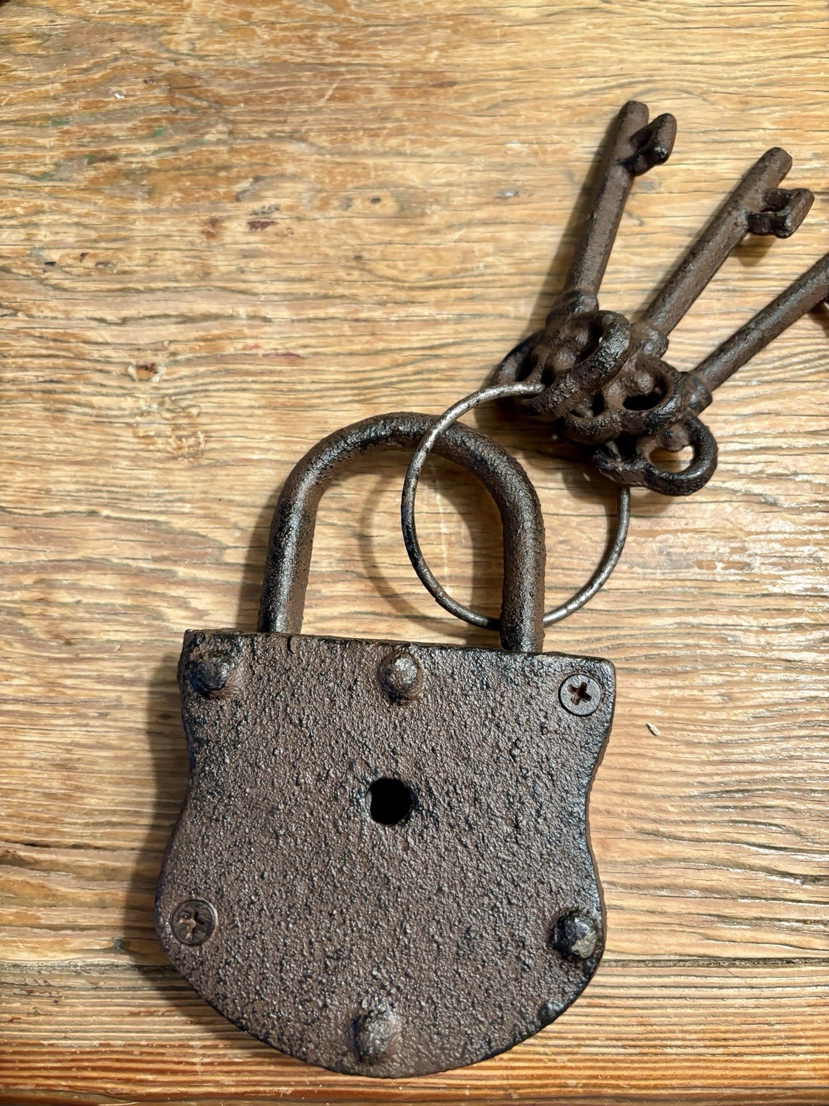 Vintage cast iron padlock with three skeleton keys on a ring.