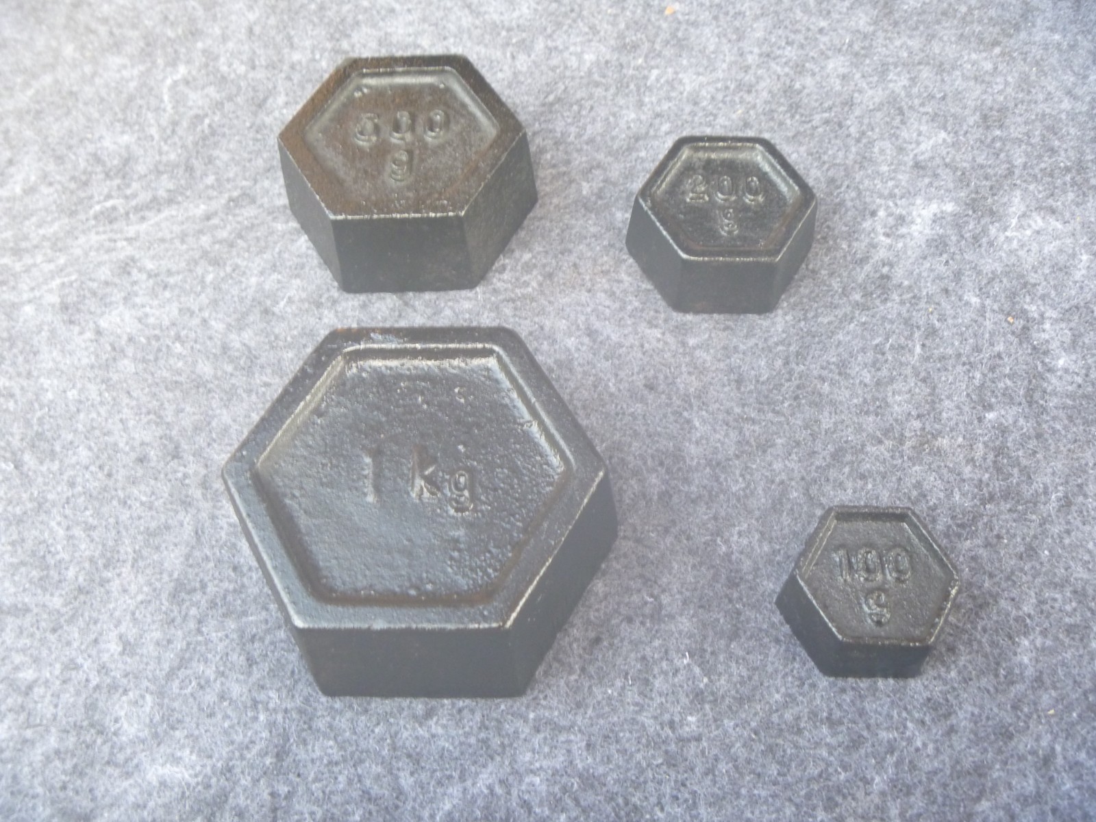 4 x Hexagon Cast Iron Scale Weights 1 x 1kg. 1 x 500g. 1 x 200g . 1 x 100g..